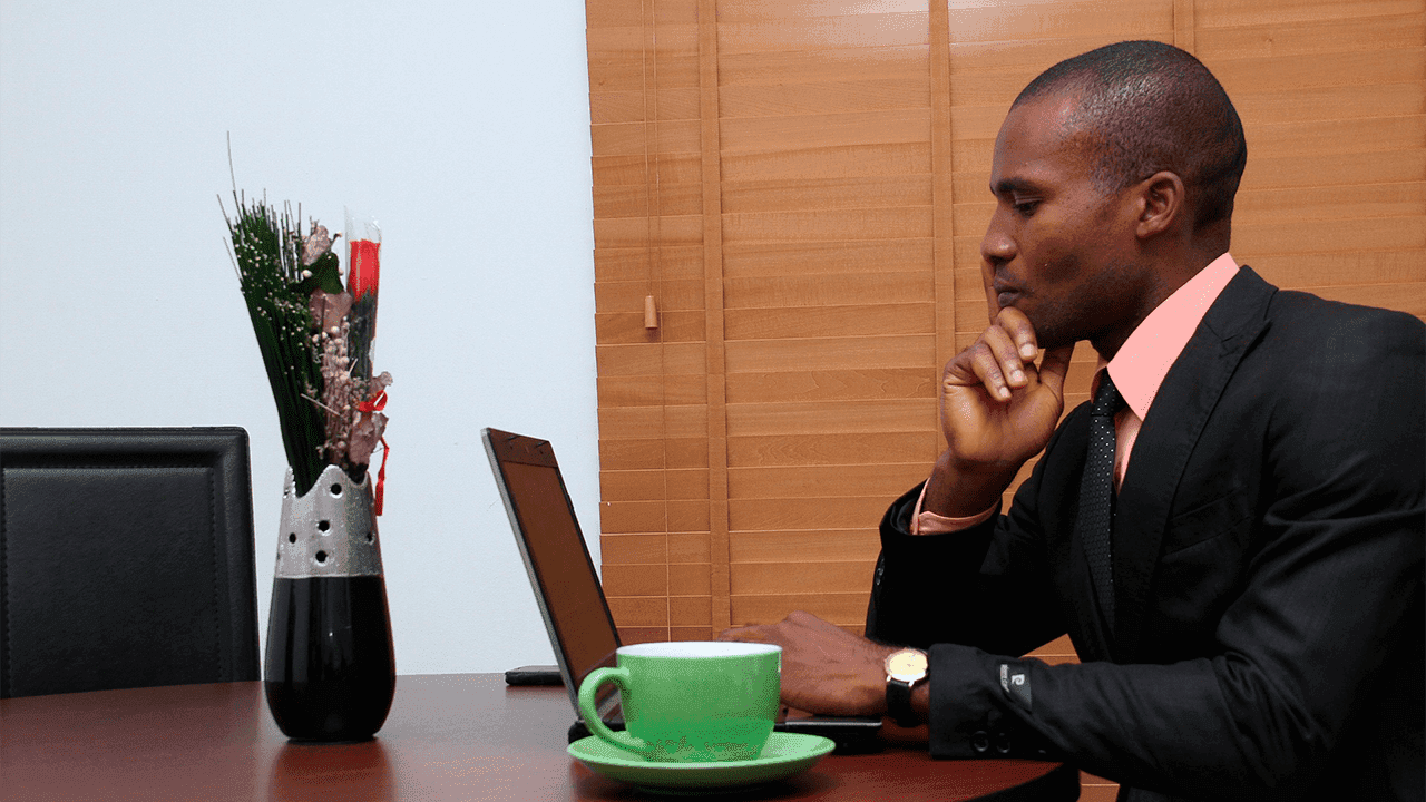 Um homem trabalhando em um computador, provavelmente um advogado ou empreendedor, que são profissões que podem estar relacionadas à sustentabilidade.