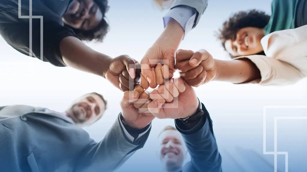 Equipe de pessoas juntando as mãos.
